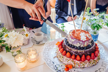 Cake cutting at wedding of Naked Cake with berries and strawberries