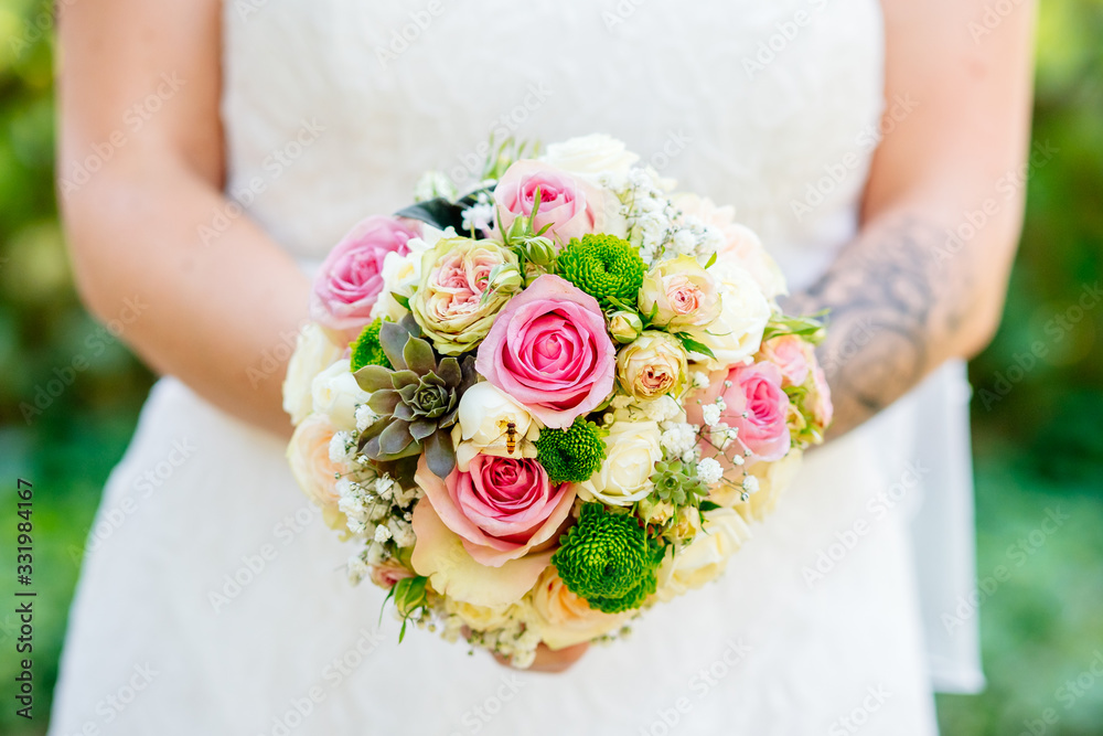 Wall mural bride holds a beautiful wedding bouquet