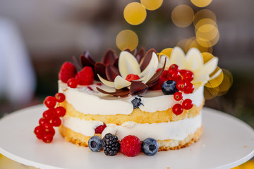 Small wedding naked Cake with cream and berries as dessert