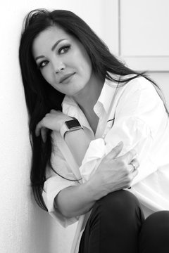 Beauty face. Beautiful woman 40 years old with healthy smooth skin. Black hair, light eyes, a white shirt, dark skin. Black and white photography.