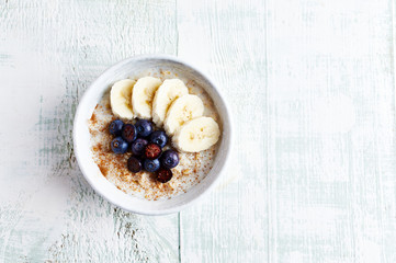 Oatmeal porridge with almond milk, banana, blueberries and cinnamon. Healthy homemade food