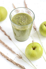 Mixed green smoothie with apples on a white background