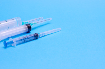 Syringes on a blue background. Medical instruments. Place for your text. Medical background
