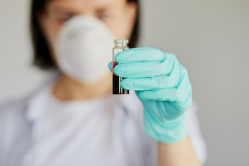 Young woman holding test tubes with blood and antidote in her hand.