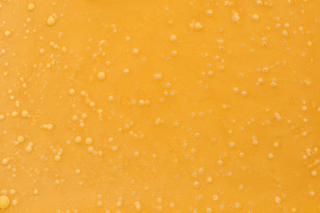 Frozen cream honey or confiture orange color, texture. Close up, top view.
