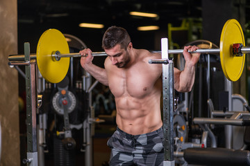 Fototapeta na wymiar Sexy muscular man doing squat exercise