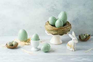 Easter holiday decorations with easter eggs, bunny and bird nest on wooden table