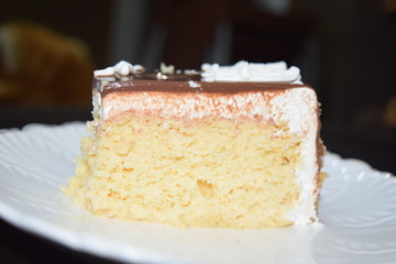 Tasty slice of  three milk cake with white plate and dark background