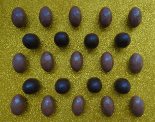 Several chocolate eggs on a gold background in a separate pattern