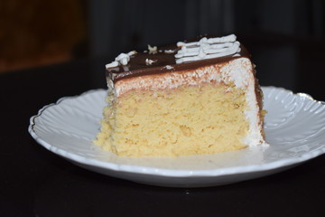 Tasty slice of  three milk cake with white plate and dark background