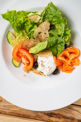salad with mozzarella and salmon, wooden background