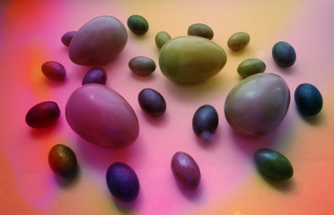 Easter composition of chocolate eggs of different sizes in multicolored light in the form of a separate pattern