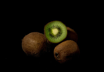 Bunch of kiwi on a black background. Kiwi is a tropical healty fruit
