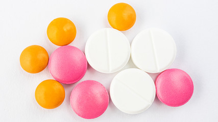 Multi-colored pills on a light background. Banner 16:9. The concept of protection against viruses, medicine, prevention and treatment of diseases. Top view, macro, flat lay, minimalism.