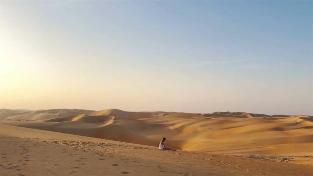 Girl among dunes in Rub al-Khali desert in United Arab Emirates