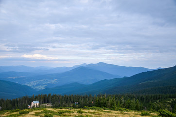 Fototapeta na wymiar View from the mountain to the ski resort Dragobrat. Hoverla and petros mountines on background. Carpathian mountains, Ukraine