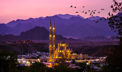 Al-Sahaba Mosque with night lights - arabic architecture and monuments in Sharm el Sheikh, Egypt. Ancient mosque of the old town at sunset with mountains silhouettes on skyline. - 331997737