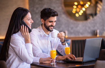 Businessman and businesswoman enjoying their free time in the cafe.