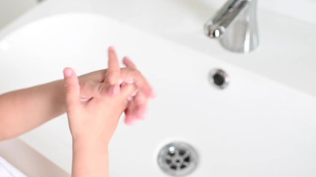 boy washing his hands after playing to fight the coronavirus