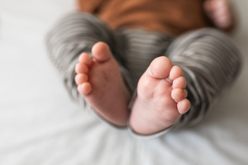 Closeup of a newborn baby feet with beautiful selective focus. Concept for maternity and tenderness