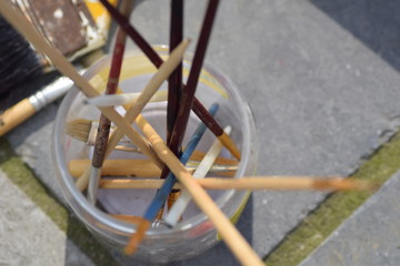close up painting brushes in a jar