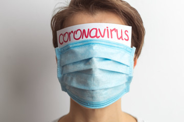 A woman is protected by a medical mask respirator from the viral disease Coronavirus. Creative concept.
