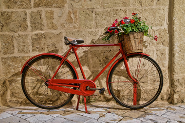Fototapeta na wymiar Old vintage bicycle with flowers in Puglia region in Italy