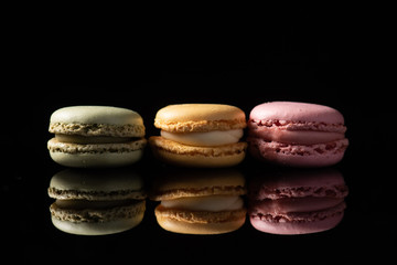 macaroons isolated in reflective black background