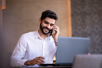 Business person talking on the phone smiling.