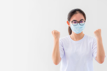 Portrait Asian young woman wears glasses and mask to protect against Coronavirus, girl show a fist encourage to fight contagious disease concept stop virus Covid 19 outbreak to win on white background