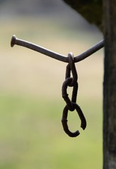 an old piece of chain hanging from a nail