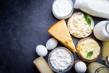 Fresh dairy products, milk, cottage cheese, eggs, yogurt, sour cream and butter on black...