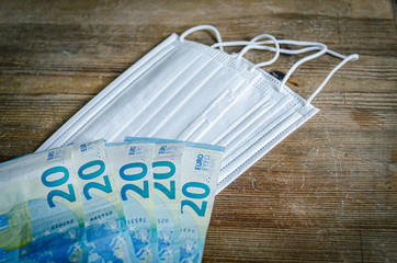 A pile of white paper filter masks and euro bills