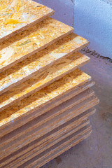 OSB slab building material made from reborn sawdust. They are stacked. Close-up