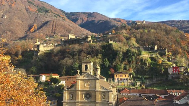Stunning aerial panorama view of Bellinzona old town with church Chiesa Collegiata dei SS Pietro e Stefano, Montebello castle and Swiss Alps in background, on sunny autumn day, Ticino, Switzerland