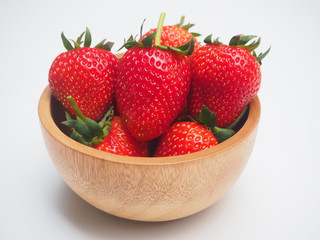 Red strawberry ripe in a wood bowl on isolated background using for healthy or diet food concept.