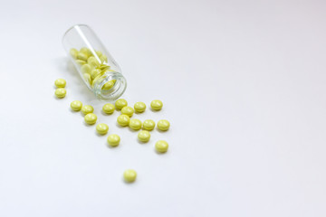 Yellow pills with bottle on white