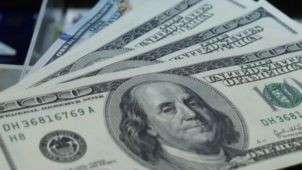 American dollars stacked on a dark background, in a wallet, in a cash drawer