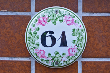 A house number plaque, showing the number sixty one (61)