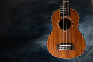 Hawaii ukulele guitar isolated against black background with smoke