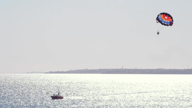 Timelapse tourists on a parachute over the sea. Parasailing in the red sea. Active sports and leisure concept 4k