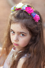 Portrait of cute sad little girl looking sad at summer day