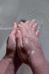 Fototapeta premium people washing hands in sink with a bar of soap to kill coronavirus disease with Alcohol-based hand sanitizer and antibacterial soap to fight germs in a running water. stay home and wash your hands