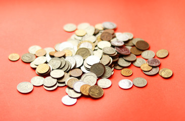 A bunch of different metal coins on a red background. A lot of Russian rubles. Selective focus. Collecting