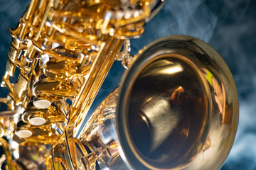 Obraz na płótnie Canvas Golden shiny alto saxophone on black background with smoke. copy space
