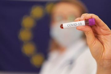 Fototapeta premium doctor is standing against the background of the European Union flag. COVID-19 test and laboratory sample of blood testing for diagnosis new Corona virus infection