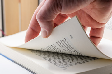 Holding several pages of a book with the fingers of the hand