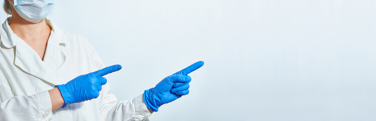 Female hands of a paramedic, nurse or doctor in blue gloves with copy space for product or text advertising.