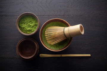 Matcha powder. Organic green matcha tea ceremony. Healthy drink. Traditional japanese drink on black wooden background