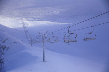 Ski lift in the fog in the early spring in mountains